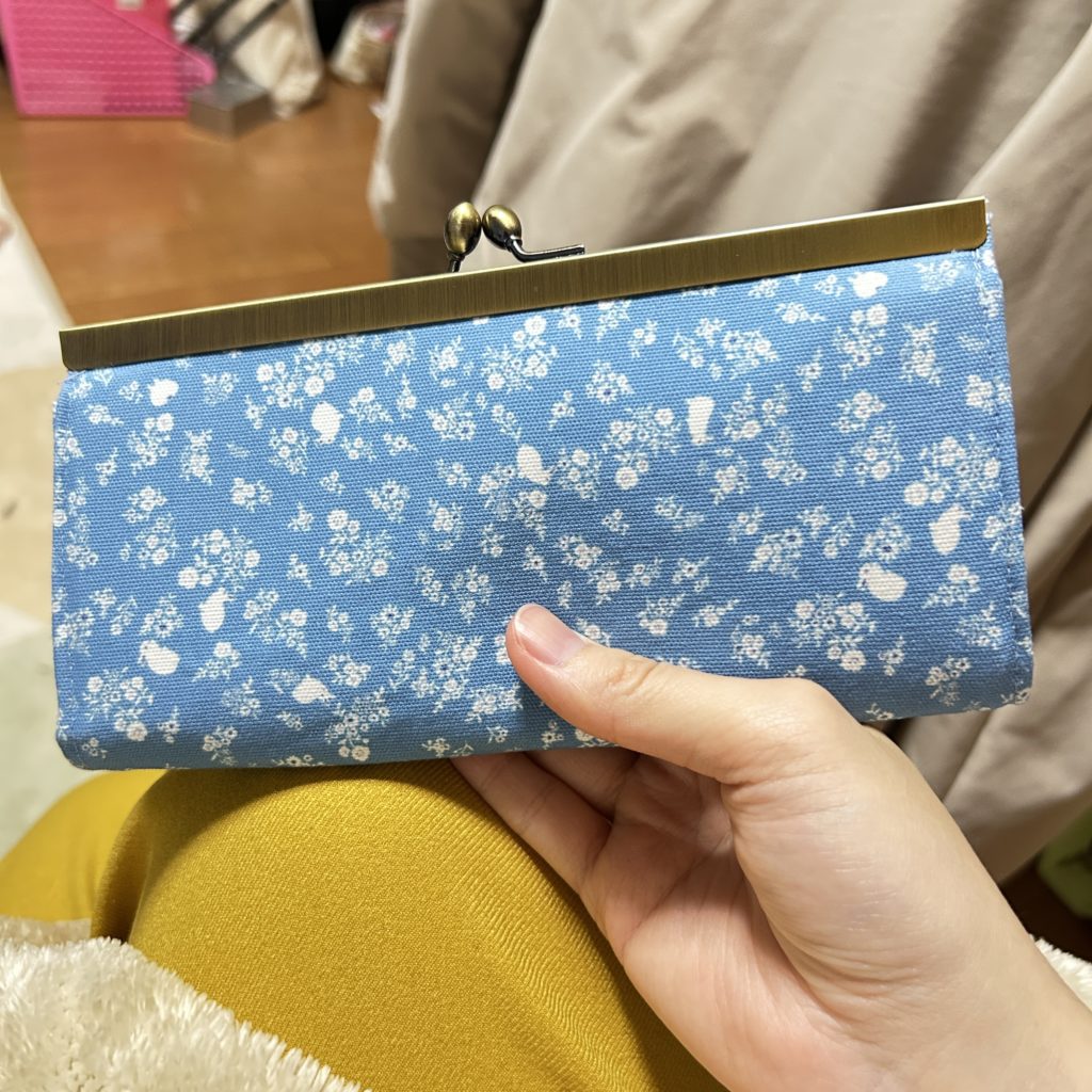 水色の背景色に、白色うさぎと花の柄が入った生地で作ったがま口長財布
